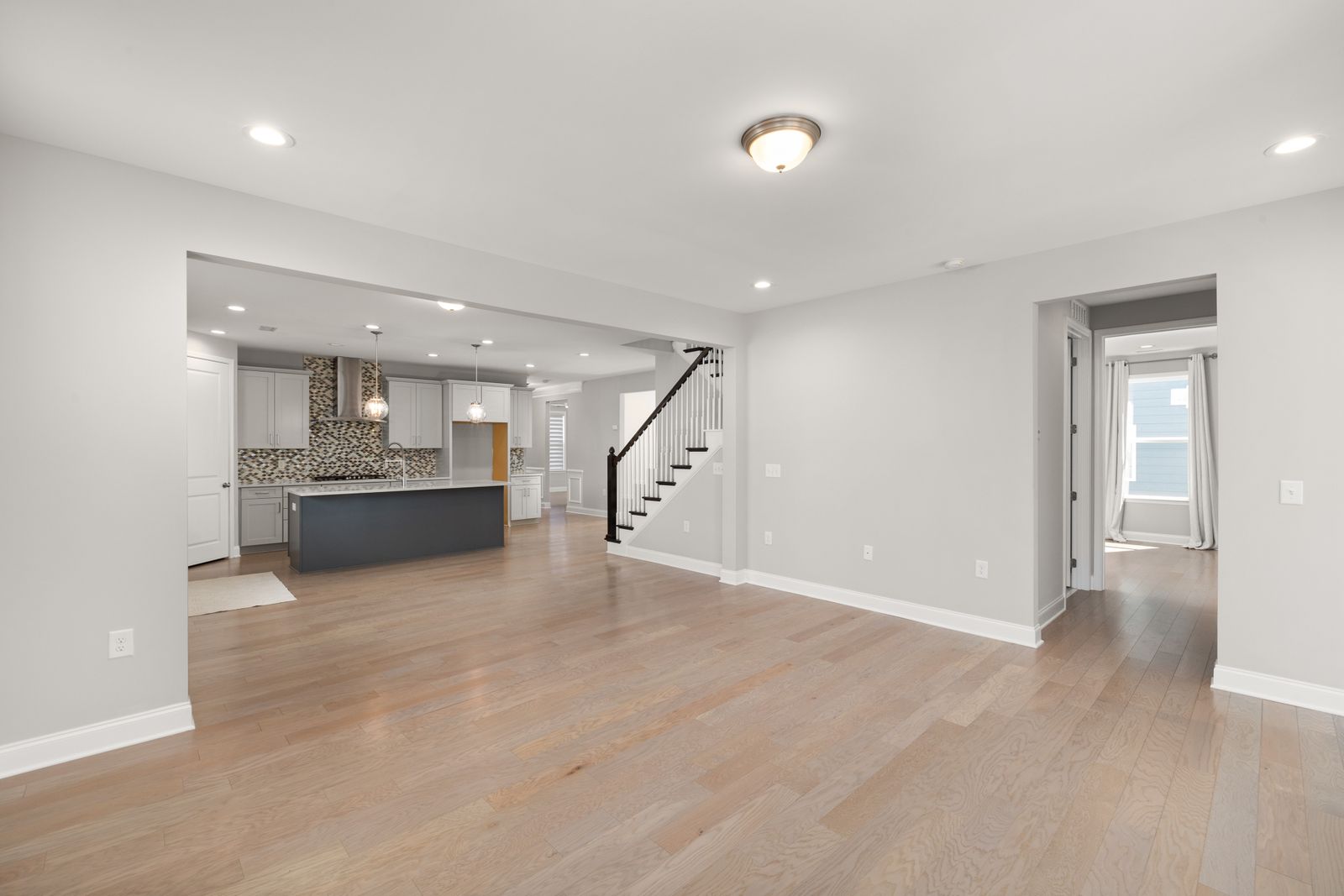 Open-concept living room and kitchen with plank flooring throughout