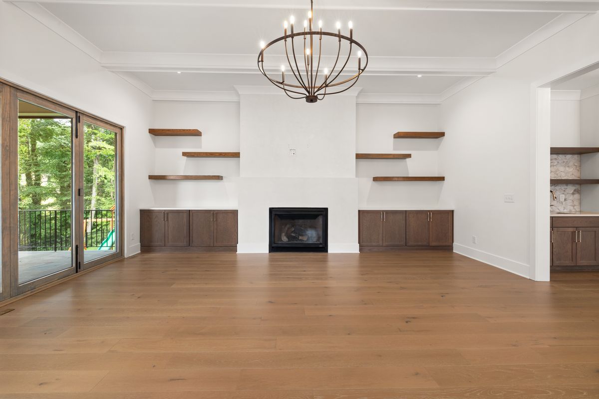 Installer measuring and marking wood floor planks mid-install
